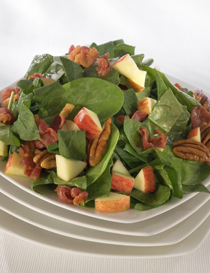 Fresh spinach salad with apples and nuts.