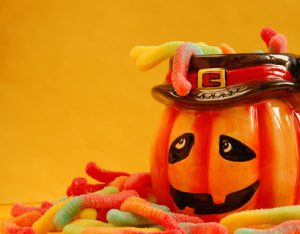 Halloween pumpkin with candy worms around it.