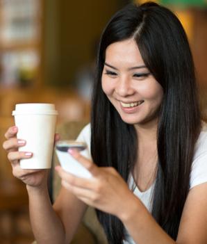 Young woman enjoying coffee and texting.