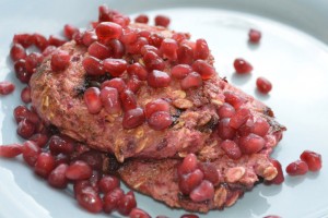 Pancakes topped with pomegranate seeds.