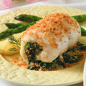 Baked fish with greens and asparagus garnish.