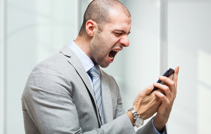 Man in suit yelling at smartphone.