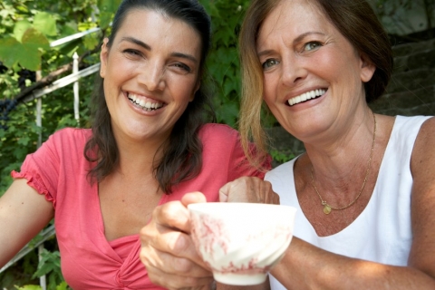 Two women smiling with a tea cup.